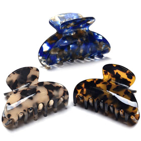 Fsmiling front view of three tortoise claw clips showing patterns and finish