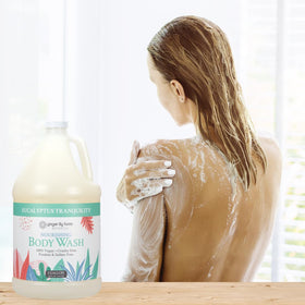 Ginger Lily Farms bottle in a spa shower setting conveying calming eucalyptus scent
