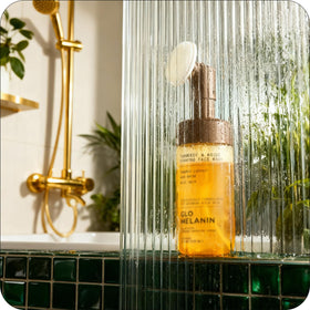 Glo Melanin foaming face wash applied on cheek showing gentle in-routine use