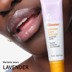 Glossier Balm Dotcom beside common items showing compact travel-friendly size