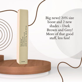 Glossier Boy Brow beside a coin illustrating compact travel-friendly size