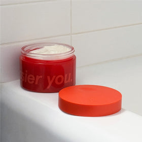 Glossier lifestyle scene on bedside implying nightly moisturizing and comforting scent