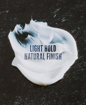 Hand applying GO247 grooming cream to damp hair for shaping and frizz control