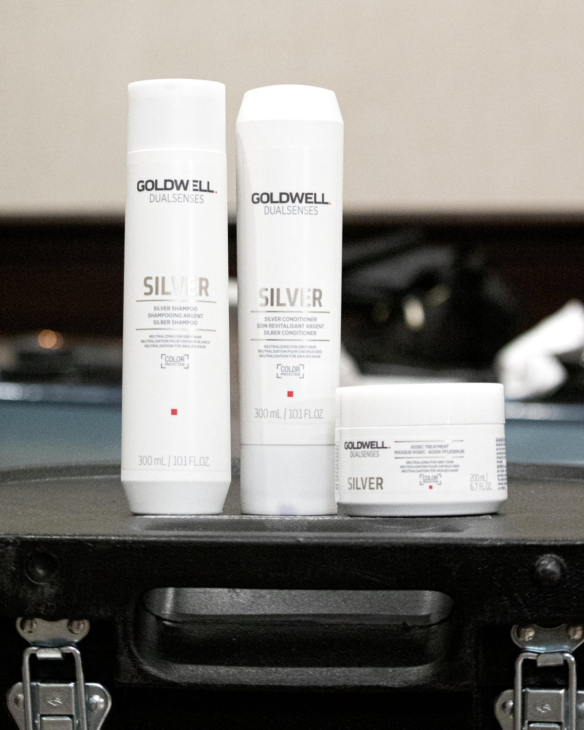 Goldwell 300mL bottle beside a hand for size and scale clarity