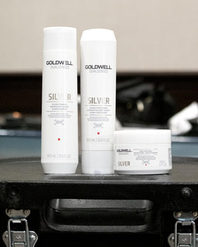 Goldwell 300mL bottle beside a hand for size and scale clarity