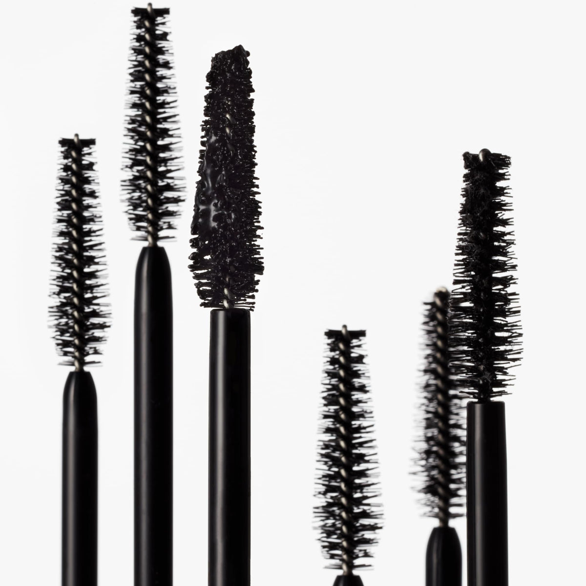 goop Featherlash next to a coin for scale, clarifies compact 0.15 fl oz size