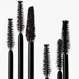 goop Featherlash next to a coin for scale, clarifies compact 0.15 fl oz size