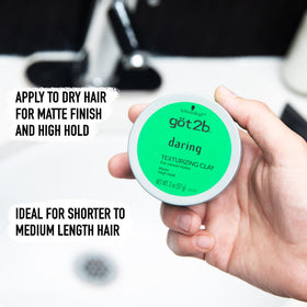 got2b applying clay on hands for even distribution and control benefit styling