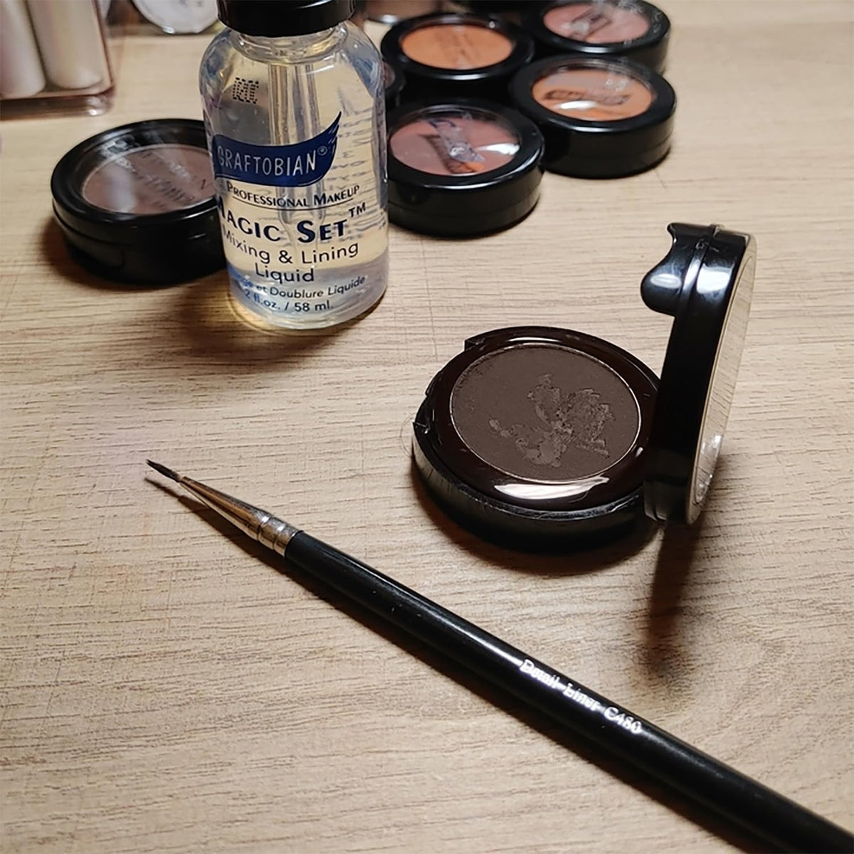 Graftobian cake liner next to brushes showing portability and toolkit compatibility
