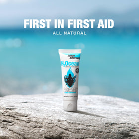 H2Ocean Aquatat beside a coin for scale displaying the small 0.75 oz travel-friendly tube