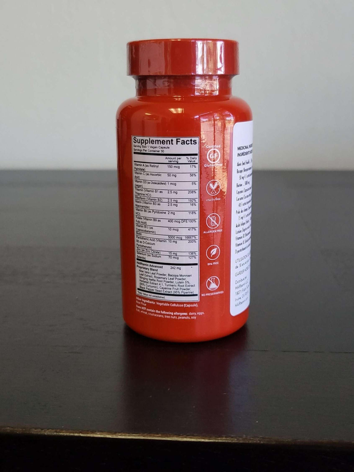 HAIRtamin bottle beside herbs conveying botanical antioxidants and support