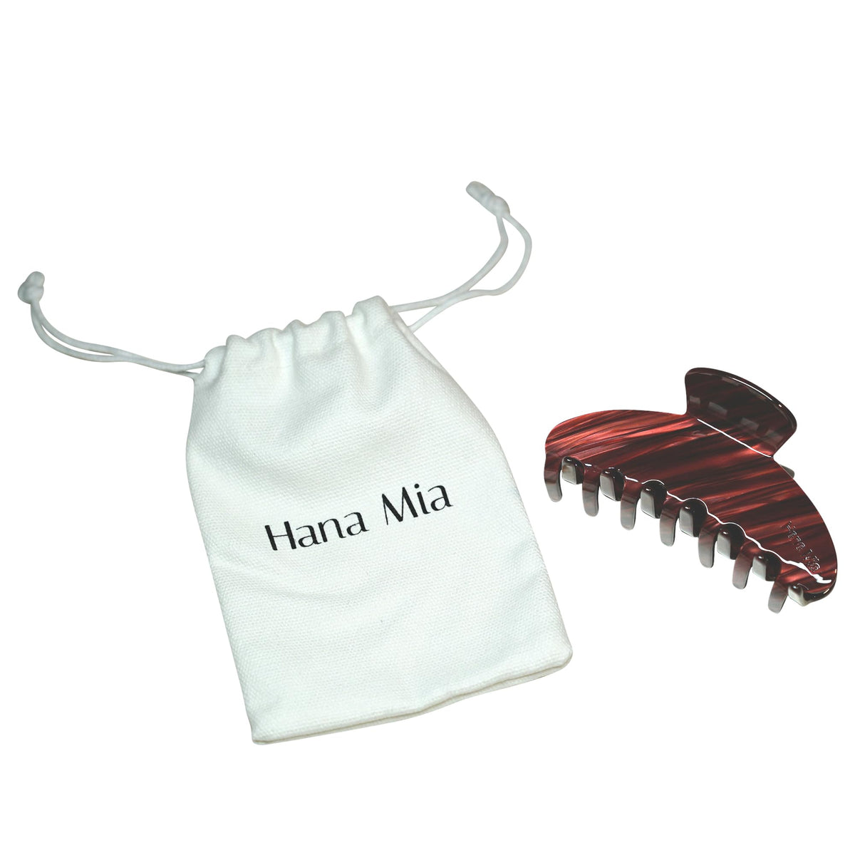 Hana Mia in a purse beside daily items, travel-friendly convenience