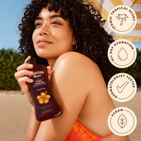 Hawaiian Tropic bottle on sandy beach displaying tropical fragrance vibe