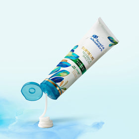Hand holding Head & Shoulders bottle to show product size and portability
