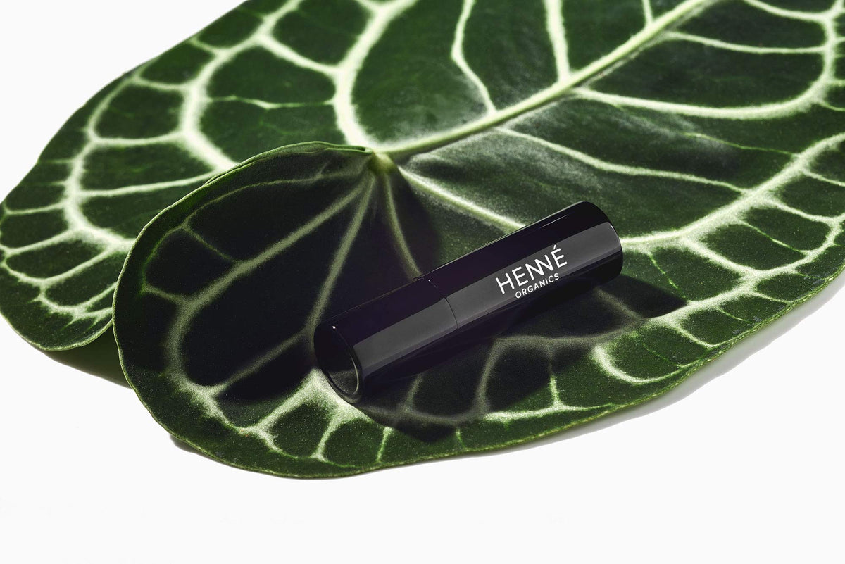Henné Organics lip balm held in hand to show scale and pocketable convenience