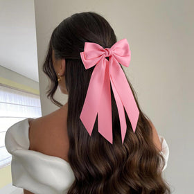 hisial bow worn on a high ponytail, adds polished decorative accent