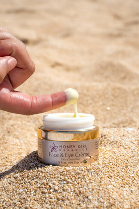 Finger dipping small amount of Honey Girl Organics creme to demonstrate concentrated application