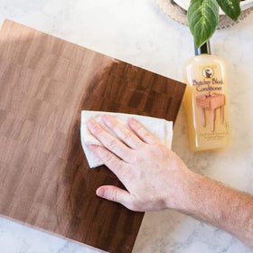 Howard BBC012 being applied to a cutting board with a cloth showing improved moisture