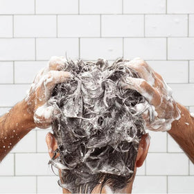 Huron conditioner on bathroom shelf styled in lifestyle shot conveying fresh scent benefit