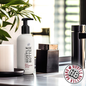 Hustle Butter with shea aloe jojoba ingredients arranged to highlight natural formulation