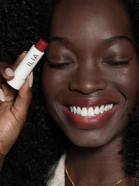 ILIA Balmy Tint next to a credit card illustrating compact travel-friendly size