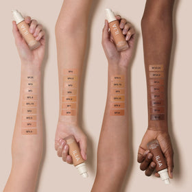 ILIA bottle next to coin conveying true 30 ml size and travel convenience