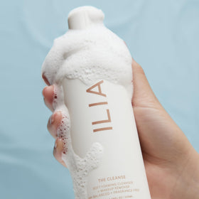 ILIA bottle in travel bag suggesting portability and on-the-go skincare convenience
