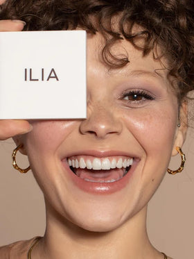 ILIA compact shown beside fingers to show size and travel friendly scale