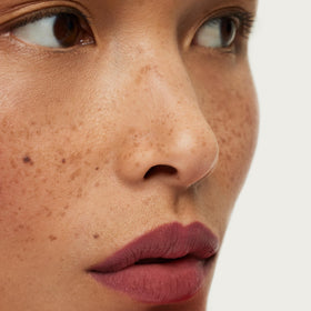 ILIA lip crayon held in hand to show size and travel-friendly benefit