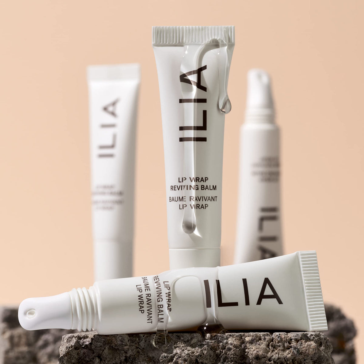 ILIA Lip Wrap held in hand to show compact 7 ml size and portability benefit
