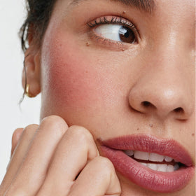 ILIA applying multi-stick to cheek demonstrating quick, buildable color