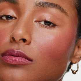ILIA applying multi-stick to lips showing rich berry coverage and comfort
