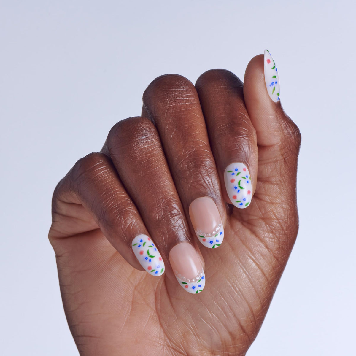 imPRESS close-up of arranged nails showing multicolor florals and French tips for spring style