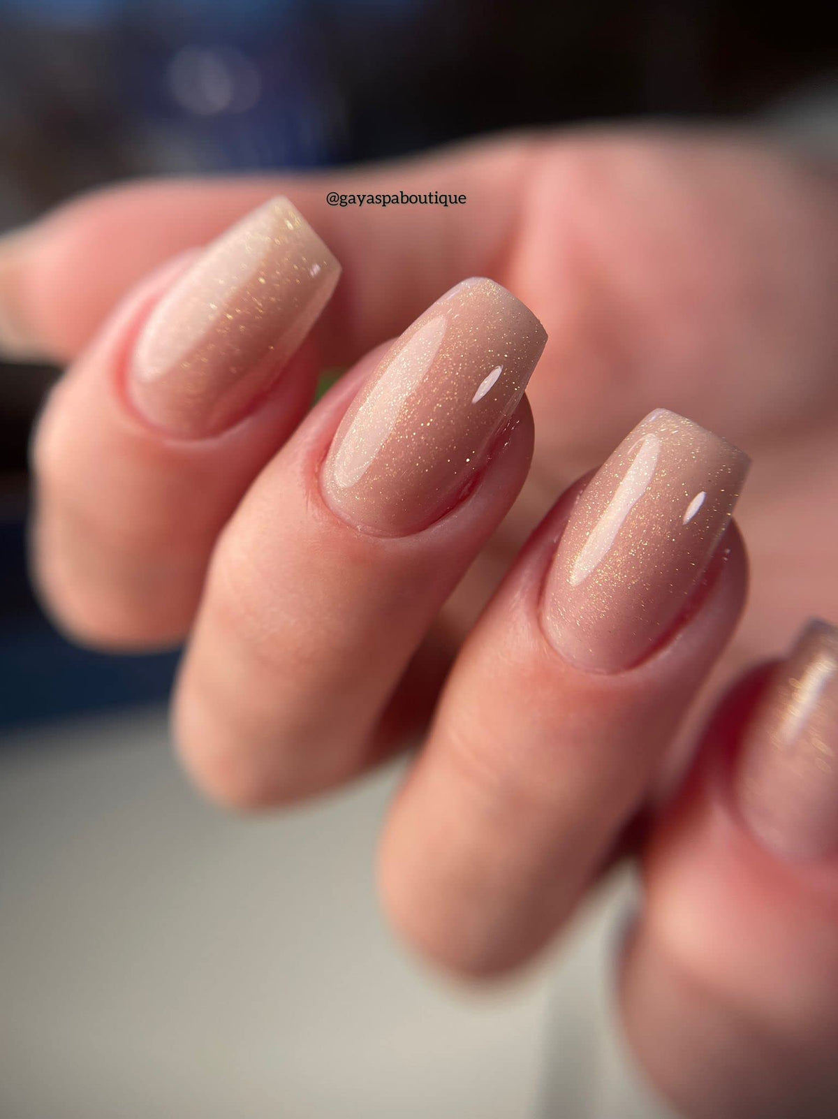 IN.HYPE cured manicure on hands displaying natural shimmer nude finish and polished result