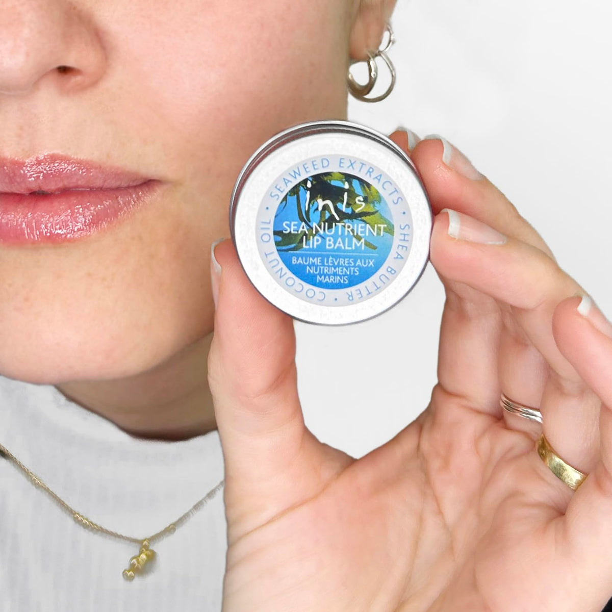 Inis Sea Nutrient Lip Balm held in hand to show 0.5 oz size and travel-ready aluminium tin