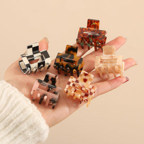 Interesse miniature clips in hand to show 1.3-inch compact size and portability