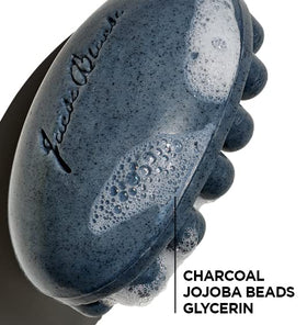 Jack Black body bar in hand under shower demonstrating massage action and cleansing