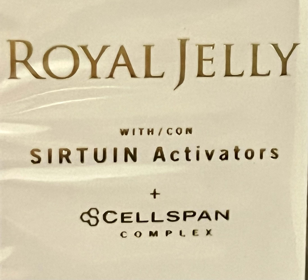JAFRA Royal Jelly milk balm next to a coin for scale to highlight the convenient 1 fl. oz. travel size