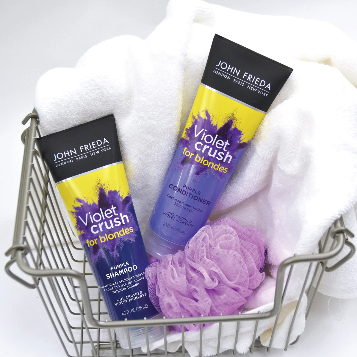 Hands holding John Frieda bottles next to ruler for scale showing travel-friendly 8.3 oz size