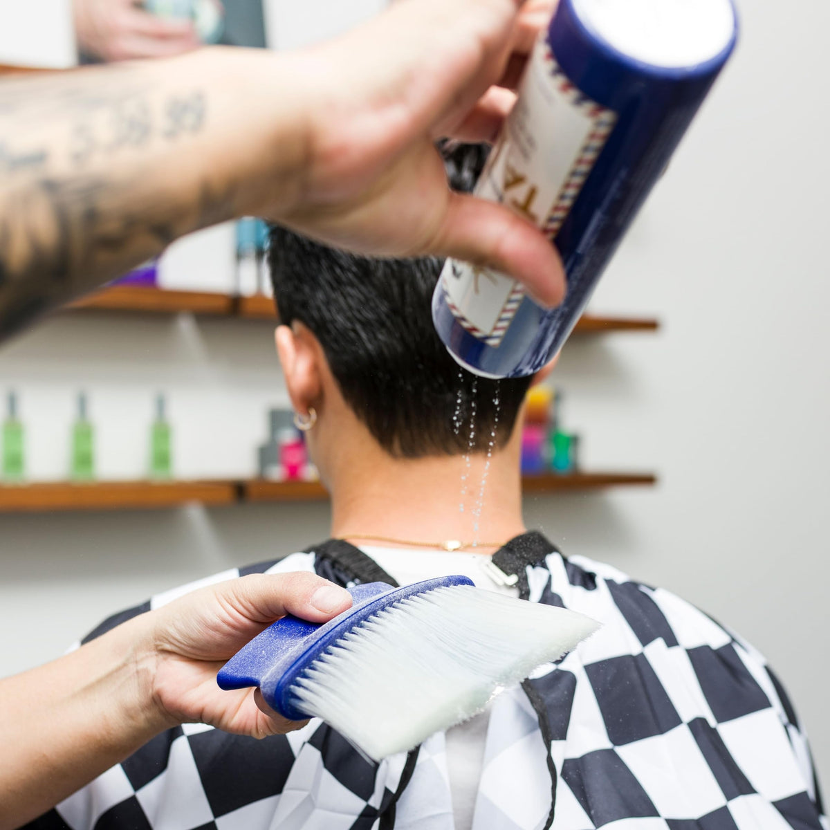 JOHNNY B. barber applying talc to client's neck for comfort and moisture control
