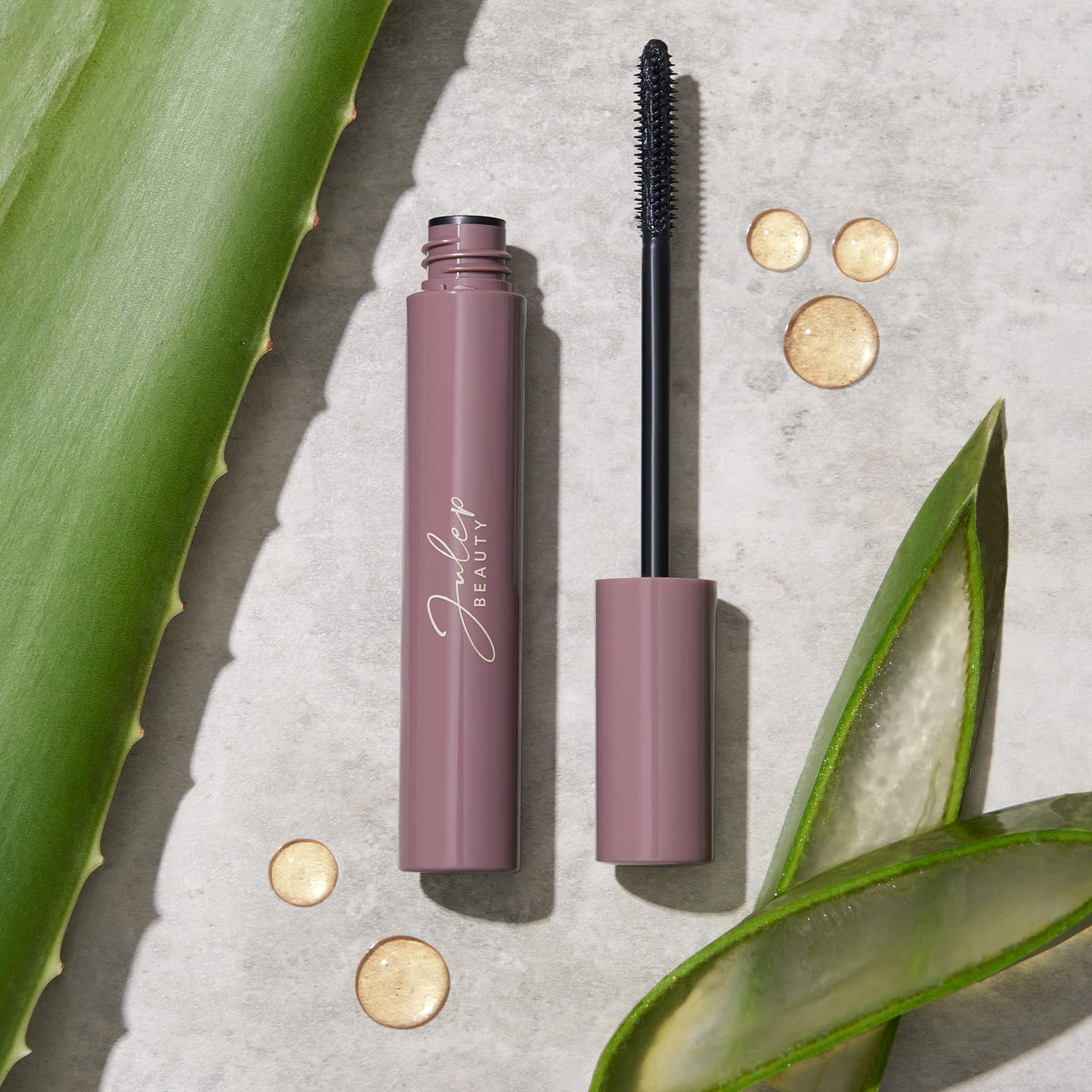 Julep mascara next to a coin to show compact 0.34 fl oz size benefit