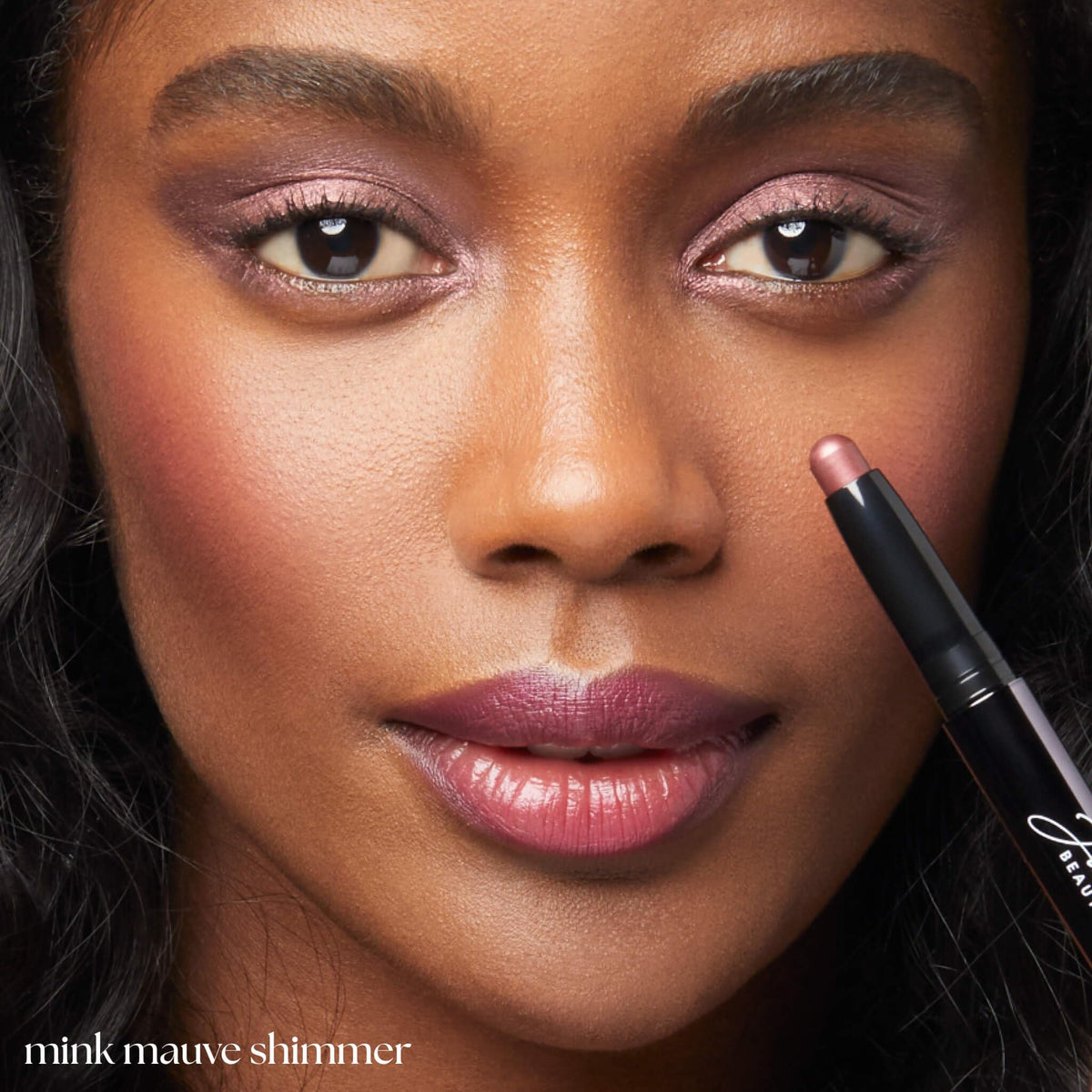 Julep Mink Mauve stick held in hand to show compact size and travel convenience