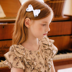 KCHIES bow held in hand demonstrates one-size practicality and scale