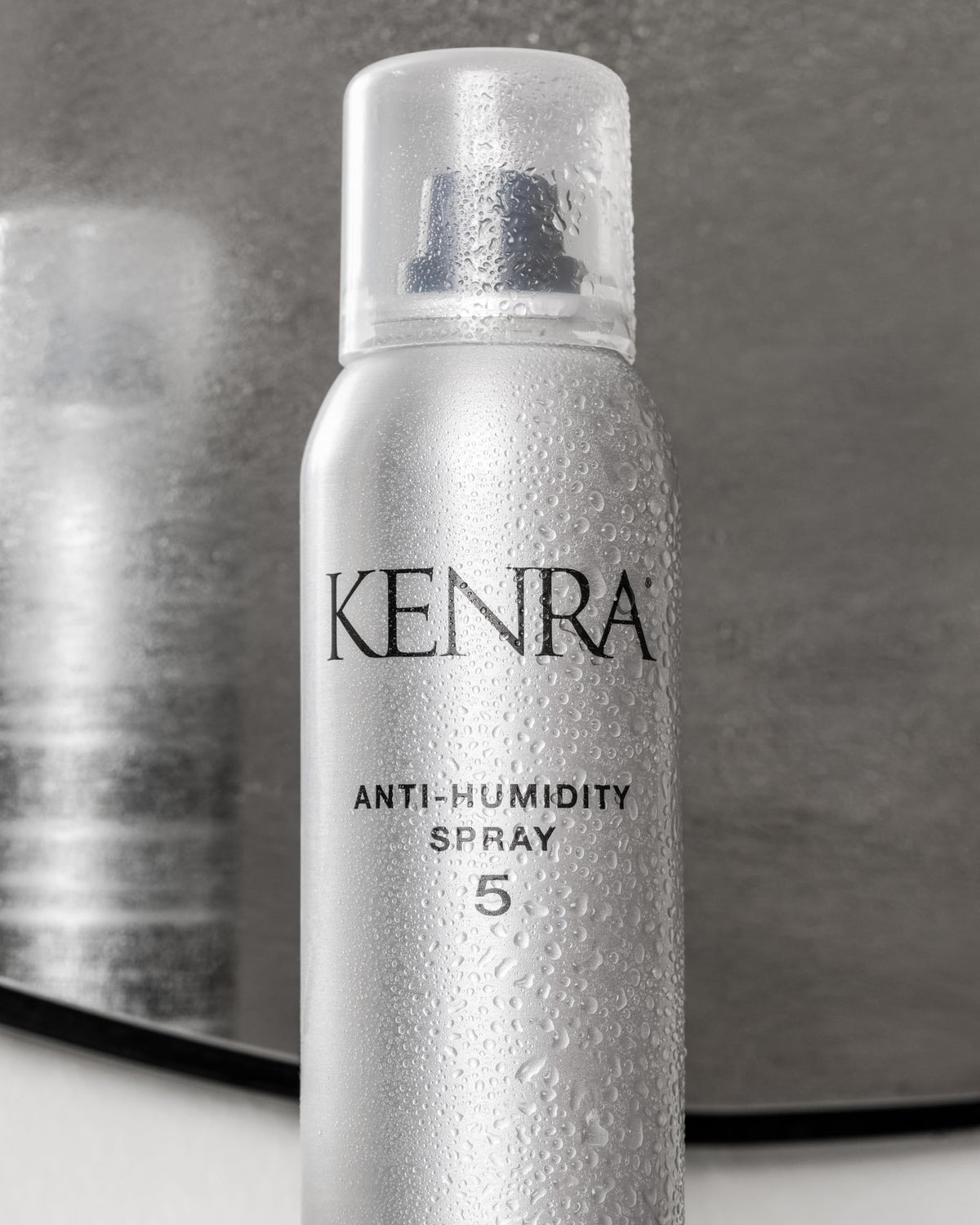 Kenra anti-humidity spray 5 held in hand showing compact 5oz size