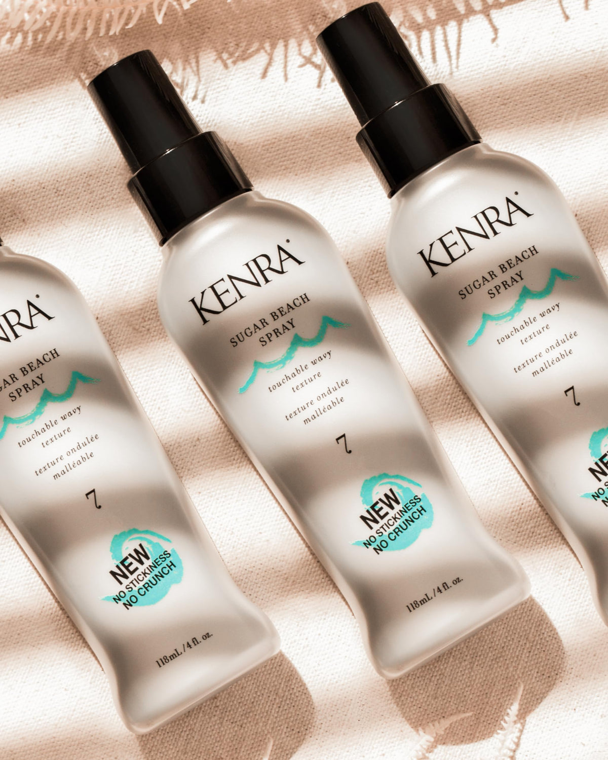 Kenra Sugar Beach Spray 7 in hand to show 4 fl oz size and travel convenience