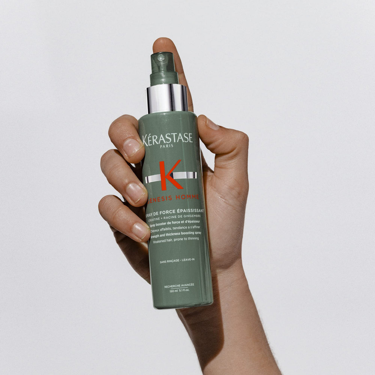 KÉRASTASE bottle in hand for size comparison and travel-friendly benefit