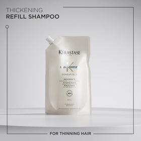 KÉRASTASE pouch held in hand to show 500ml scale and convenience benefit