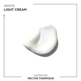 KÉRASTASE Nectar Thermique bottle shown next to hand for size and scale