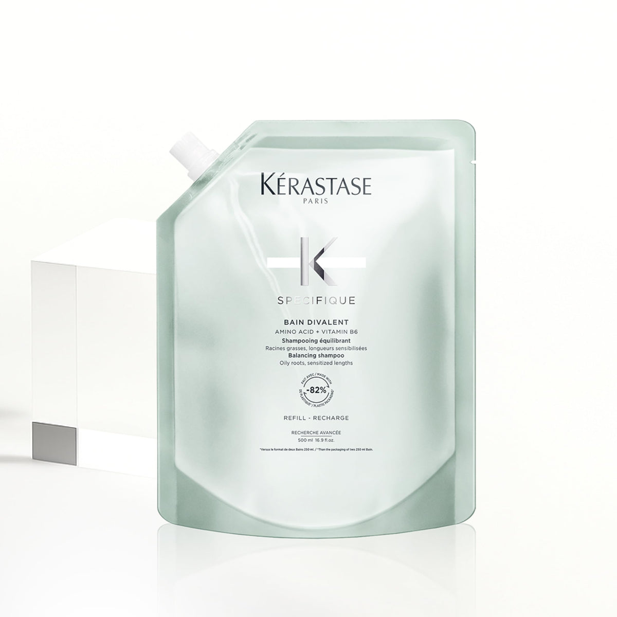 KÉRASTASE pouch next to original bottle showing compact refill size