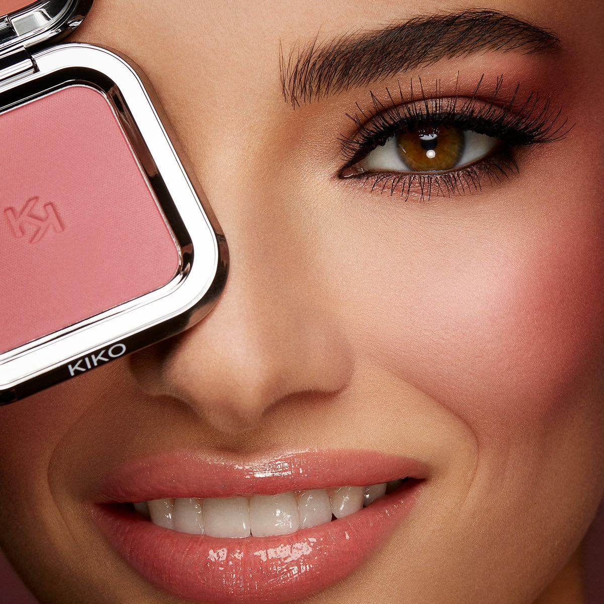 KIKO Milano blush in hand during touch-up showing mirror use benefit: quick on-the-go application